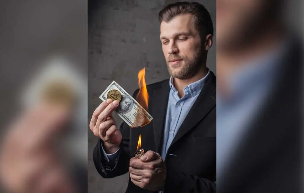 Man burning one hundred dollar note